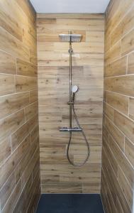 a shower in a bathroom with wooden walls at Chalet de standing 9P avec sauna & salle d'escalade in La Bresse