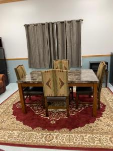 a dining room with a table and chairs on a rug at Zion's Most Wanted Hotel in Hildale
