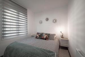 a white bedroom with a bed and a window at Mar & Sol Spain in Empuriabrava