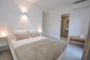 Un dormitorio blanco con una cama grande con dos almohadas. en ALCUDIA PLAYASOL, en Alcudia