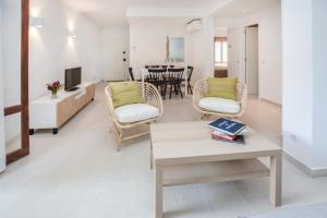 Una sala de estar con una mesa y sillas y un televisor. en ALCUDIA PLAYASOL, en Alcudia