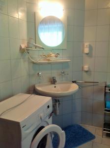 uma casa de banho com um lavatório e uma máquina de lavar roupa em s'Hoamatl em Neukirchen am Grossvenediger