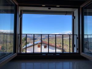 a large window with a view of a house at La Casetta in Bosco Chiesanuova