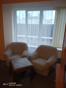 twee stoelen en een salontafel voor een raam bij Двухкомнатная квартира с видом на Дворец Украина in Kiev