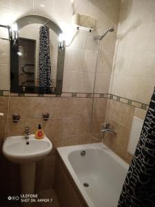 een badkamer met een wastafel, een bad en een wastafel bij Двухкомнатная квартира с видом на Дворец Украина in Kiev