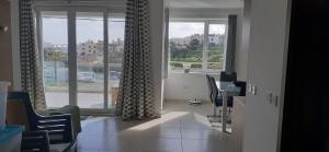 een woonkamer met een raam en een tafel en stoelen bij Sayonara in Marsaxlokk