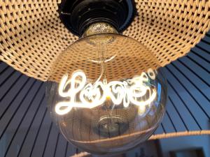 a light bulb with graffiti on it hanging from a ceiling at Chambre Cocoon dans une maison avec SPA et jardin en centre ville in Dijon