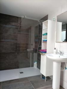 bagno con doccia, lavandino e specchio di Apartment Taliarte 36 a Vecindario
