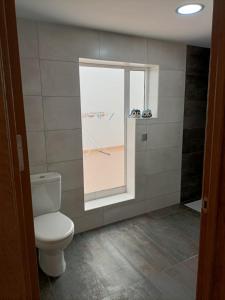 bagno con servizi igienici e finestra. di Apartment Taliarte 36 a Vecindario