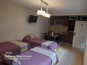 a hotel room with two beds and a kitchen at Departamentos Giova in Salta