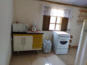 una piccola cucina con piano cottura e forno a microonde di Recanto JF da Serra a São Thomé das Letras