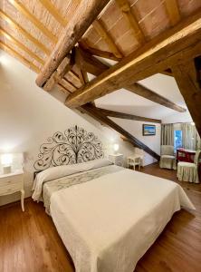 una camera con un grande letto e soffitti in legno di Ca' Settecento "Villa Cavazza Querini" a Pasiano di Pordenone