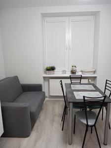 un soggiorno con divano, tavolo e sedie di Apartament Łańcut a Łańcut