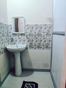 Nilachal Homes في غاواهاتي: حمام مع حوض ومرآة على الحائط