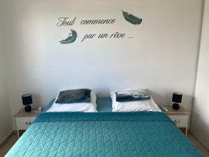 a bedroom with two beds and a sign on the wall at TURQUOISE CARAIBES in Les Trois-Îlets
