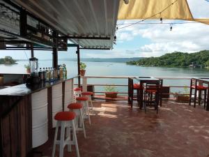 a bar with chairs and a view of the water at Hotel La Union in Flores