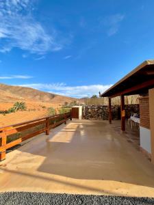 a walkway to a building with a view of the desert at La Casita del Mojino in Betancuría