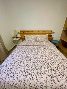a bedroom with a bed with a red and white bedspread at La Casita del Mojino in Betancuría