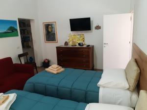 sala de estar con cama azul y TV en Casa vacanze Nonna Lucia, en Matera