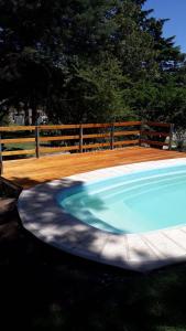 uma grande piscina num quintal com uma cerca de madeira em Shanti-om em Sierra de la Ventana