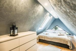 - une chambre mansardée avec un lit et une fenêtre dans l'établissement Aparthome Tatra, à Biały Dunajec