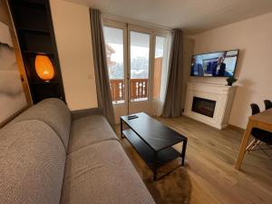 a living room with a couch and a fireplace at Appart centre station les 2 Alpes, parking, wifi in Les Deux Alpes