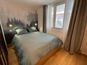 a bedroom with a bed with a painting on the wall at Appart centre station les 2 Alpes, parking, wifi in Les Deux Alpes