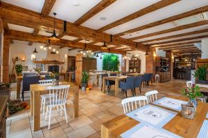 a restaurant with wooden ceilings and tables and chairs at Hotel Kuźnia Smaków in Małe Pułkowo