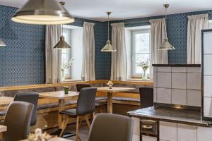a restaurant with tables and chairs and windows at Appartements Landhaus Hubertus Wellness & Breakfast in Schladming +51 photos