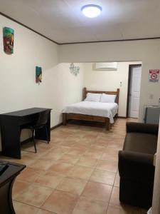 a room with a bed and a desk and a piano at Banana Bay Marina in Golfito