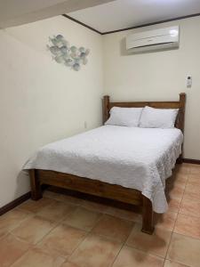 a bedroom with a bed with a white comforter at Banana Bay Marina in Golfito