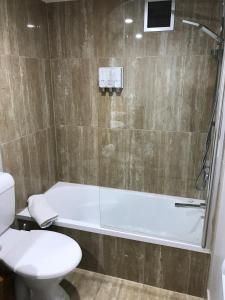 a bathroom with a tub and a toilet and a shower at Highpoint International Hotel in Gladstone