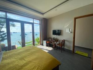 a bedroom with a bed and a view of the ocean at CHILL HOUSE by the beach in Phú Quốc