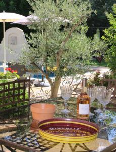 - une table en verre avec une bouteille de vin et des verres dans l'établissement La Bastide des Cyprès, à Maussane-les-Alpilles