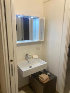 a bathroom with a white sink and a mirror at senza pensieri residence zero carlo urbino in Crema