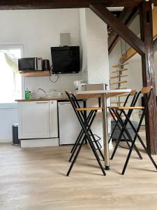 een keuken met een tafel en stoelen in een kamer bij Authentic Loft - 10 min to the city center in Schiltigheim