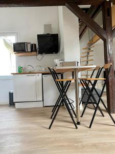 a kitchen with a table and chairs in a room at Authentic Loft - 10 min to the city center in Schiltigheim +4 photos