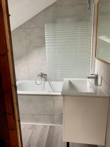 een badkamer met een wastafel en een bad bij Authentic Loft - 10 min to the city center in Schiltigheim