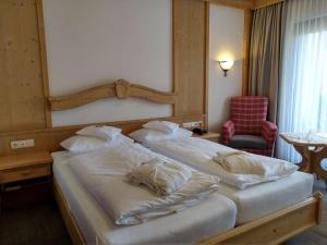 a bedroom with two beds with white pillows at Wellnesshotel Bürgerstuben in Willingen