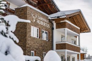 a building with a sign on it in the snow at Landhaus Hubertus in Schladming