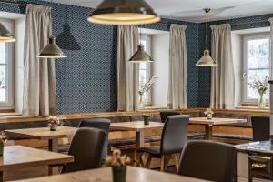 a restaurant with wooden tables and chairs and windows at Landhaus Hubertus Wellness & Breakfast in Schladming