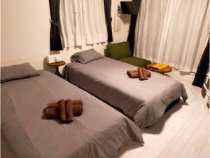 1 Schlafzimmer mit 2 Betten und einem grünen Stuhl in der Unterkunft AOCA Kaminoge - Vacation STAY 11984 in Tokio