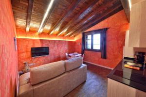 sala de estar con sofá en una habitación con paredes de color naranja en Maddiola Apartment, en Orio