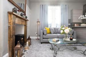 a living room with a couch and a table at Stylish George Street Apartment in Peebles