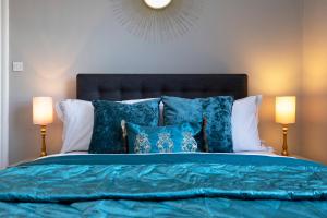 a bedroom with a bed with blue sheets and pillows at Stylish George Street Apartment in Peebles