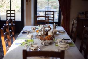 una mesa con comida y un tazón de comida en ella en B&B Manoir du Clos Clin, en Pleurtuit