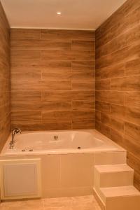 y baño con bañera y paredes de madera. en Halibut Hotel, en La Romana