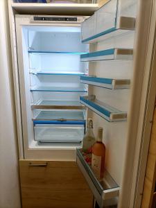 um frigorífico aberto com uma garrafa de líquido em Superb City Apartement/studio em Luxemburgo