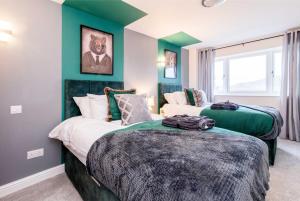 duas camas num quarto com paredes verdes em Immaculate 3 Bed House - Stunning Balcony Views em Matlock