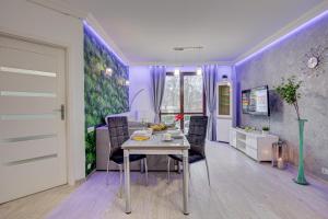 uma sala de jantar com paredes roxas e uma mesa e cadeiras em Apartamenty Silver em Szczecin